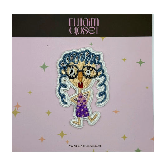 Embroidered patch of a girl with glasses and blue curly hair on a Futaim Closet card